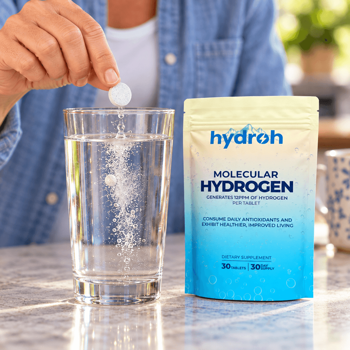 Dropping a Hydroh hydrogen tablet into a glass of water next to the pouch